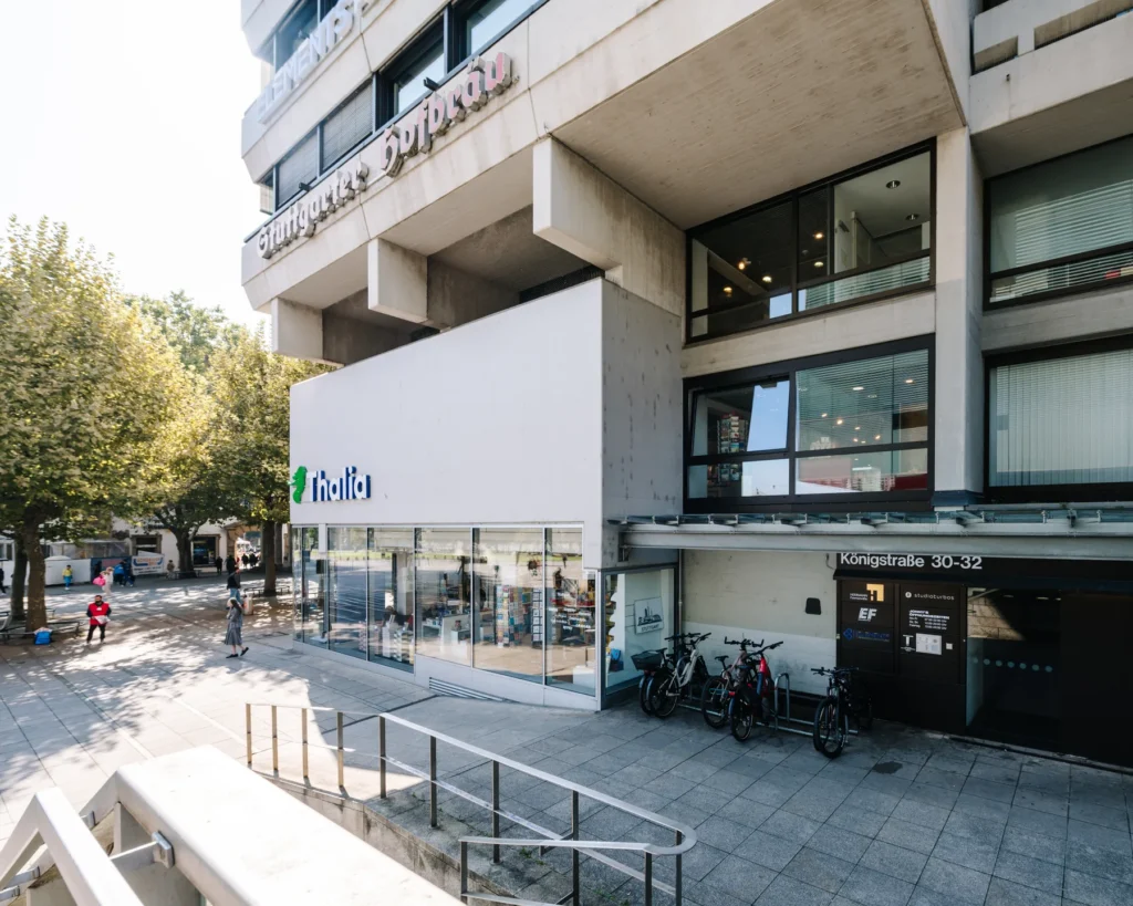 Erdgeschosszone des Wittwerhauses an der Königstraße 30/32 mit Eingangsbereich, Fahrradstellplätzen und der Betonkonstruktion darüber.
